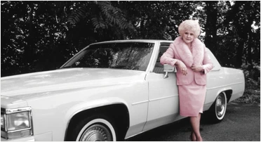 Mary Kay standing in front of the company’s iconic Pink Cadillac